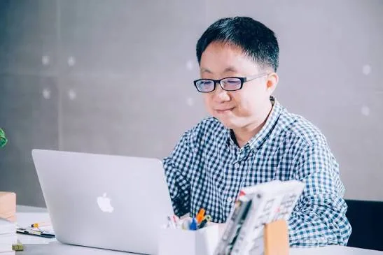 鄭緯筌（Vista）在筆電前寫作
